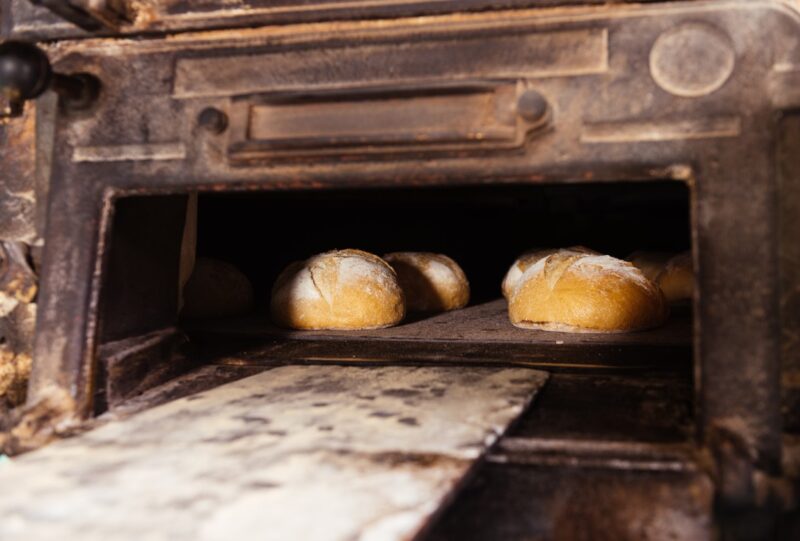 Fresh yummy delicious and appetizing breads being baked inside an oven in a bakery kitchen